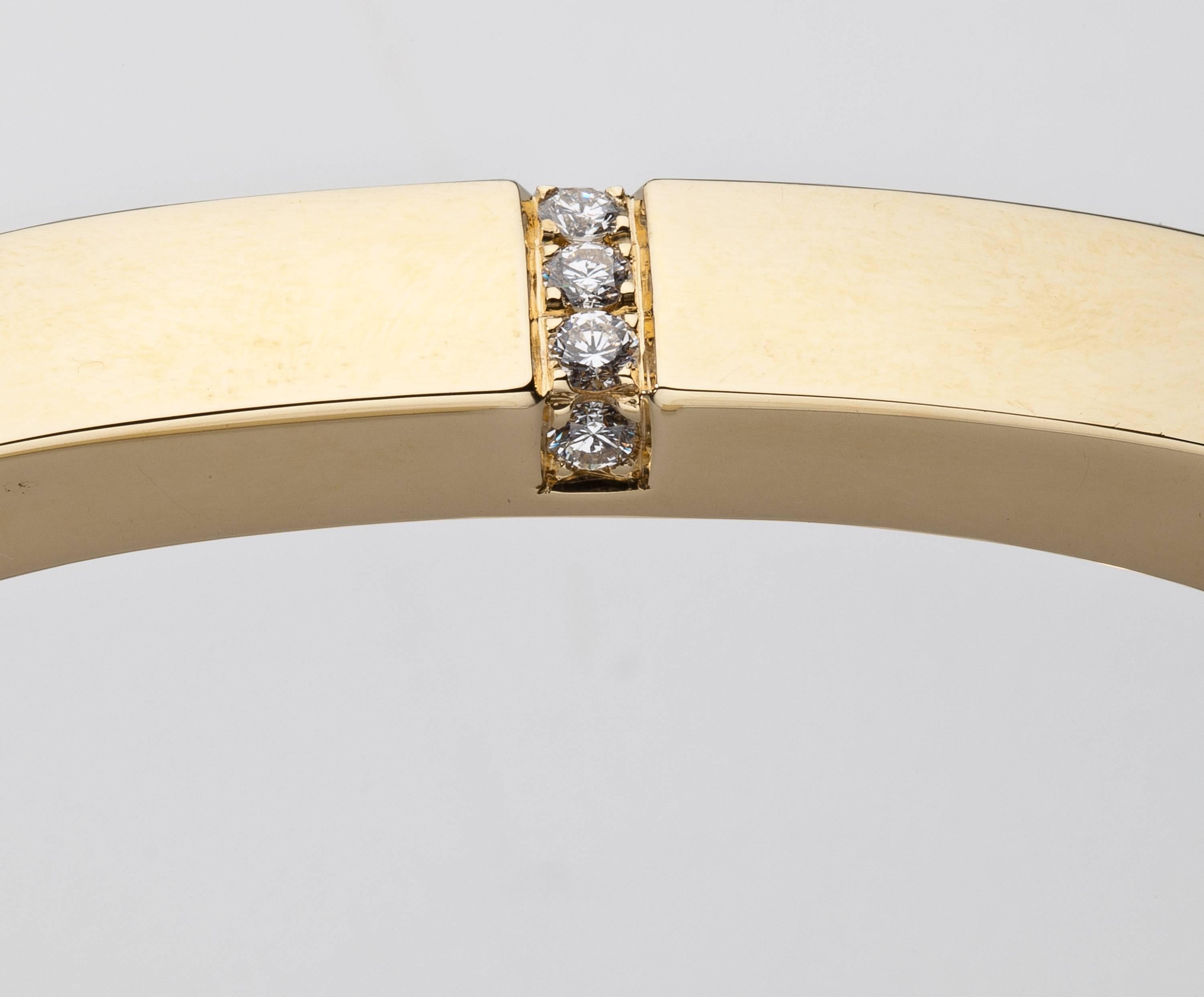 An oval shaped 18 karat gold bracelet by Mauboussin highlighted by five brilliant cut diamonds weighing .50 carat.  The shaping of this classic bracelet makes it fit on a small wrist without turning.  Signed Mauboussin Paris with maker's mark,