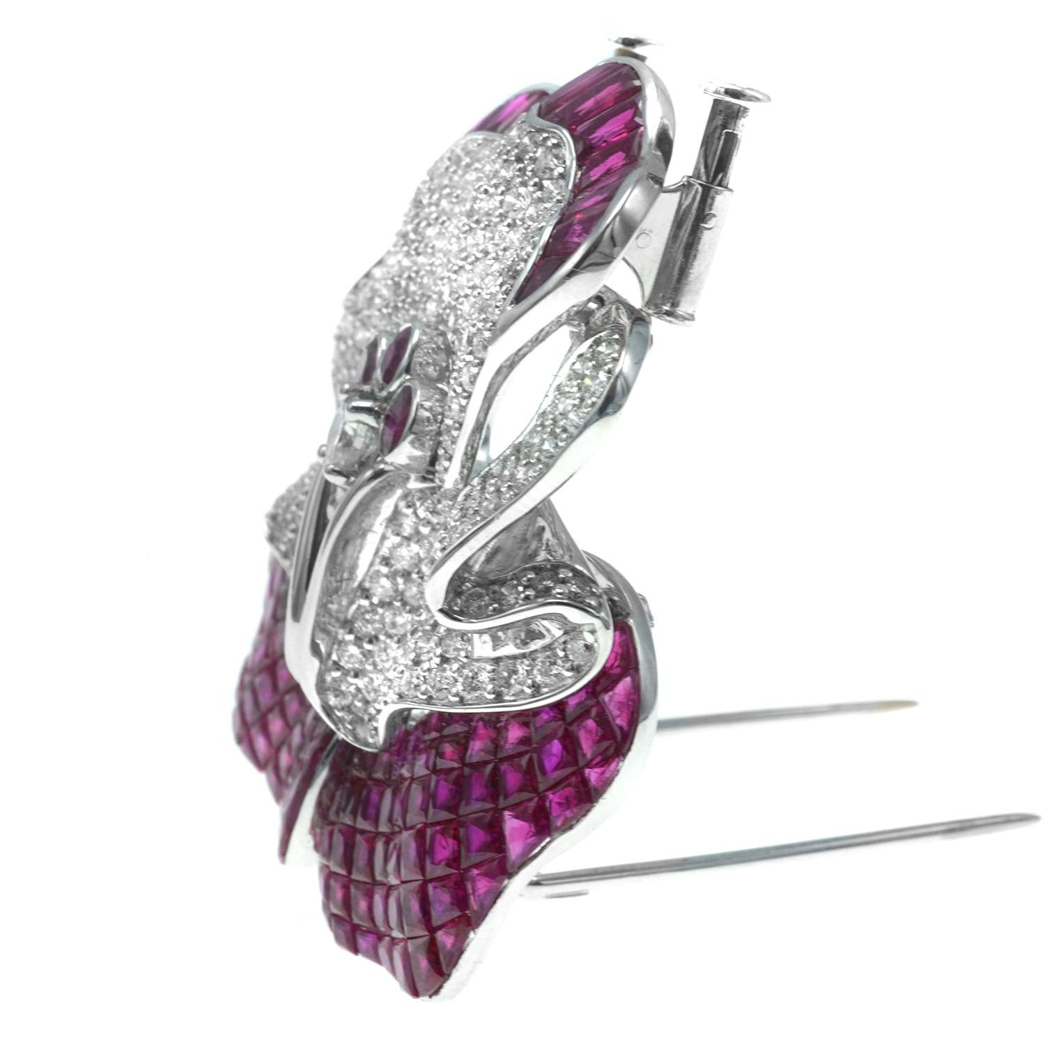 Crafted in 18 karat white gold this brooch features invisibly set fine rubies and round cut diamonds.  Dimensions L 1 3/4