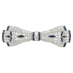 Broche vintage Art déco en platine, sertie de saphirs et de diamants, en forme de nœud