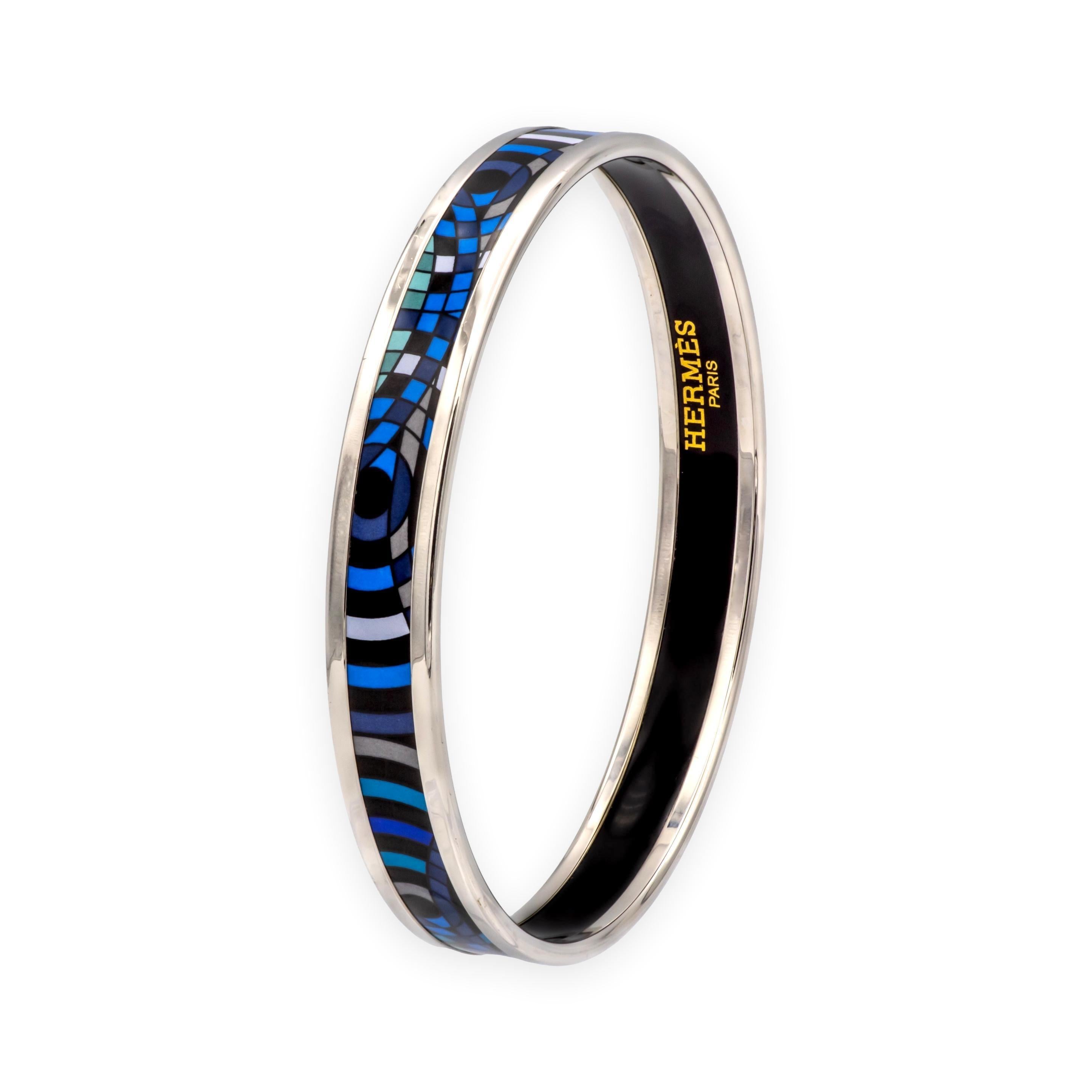 Hermès enamel bangle bracelet, featuring an abstract geometric pattern in vivid shades of blue, turquoise, and black. Finished with polished silver-tone trim and hallmarked on the interior.
Since its founding in 1837, Hermès has been celebrated for