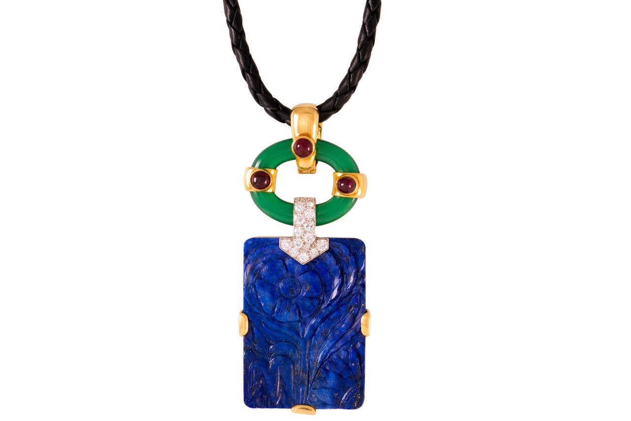 Lapis Chrysoprase Ruby Diamond Gold Platinum
Mounted in 18k gold, the carved lapis lazuli ingot of this 1970s David Webb pendant is offset by a ring of chrysoprase, deep hued cabochon rubies, and about 1 carat diamonds.  Signed.

Strung on a