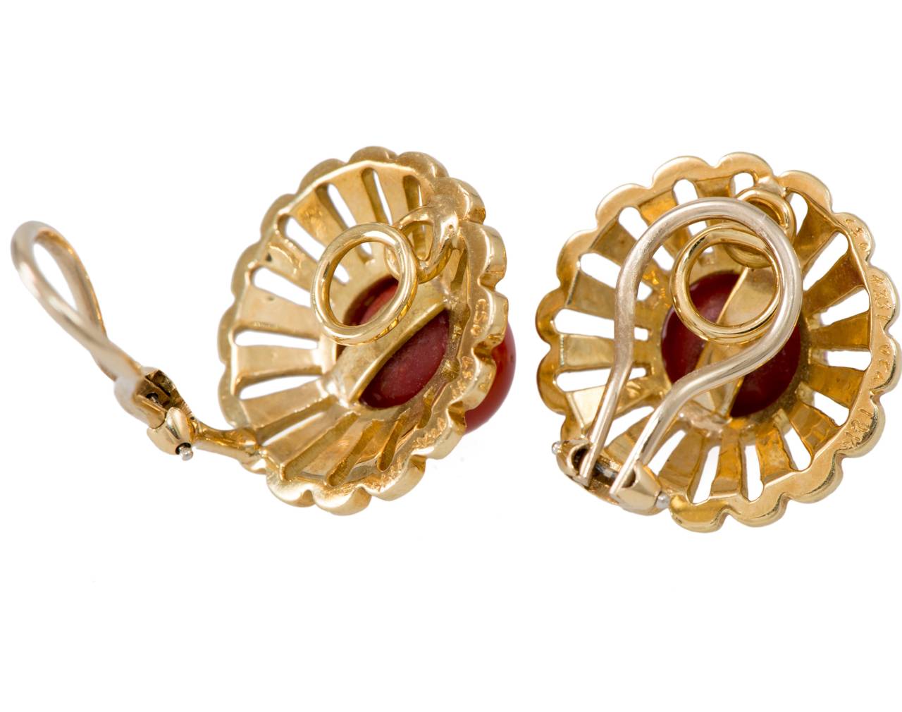 By Van Cleef & Arpels, these earrings,  in just the right color cabochon cut coral, are crafted in 18k gold with a sculpted floral surround. The perfect pair for summer day wear.

Stamped 18k, signed VCA and numbered.