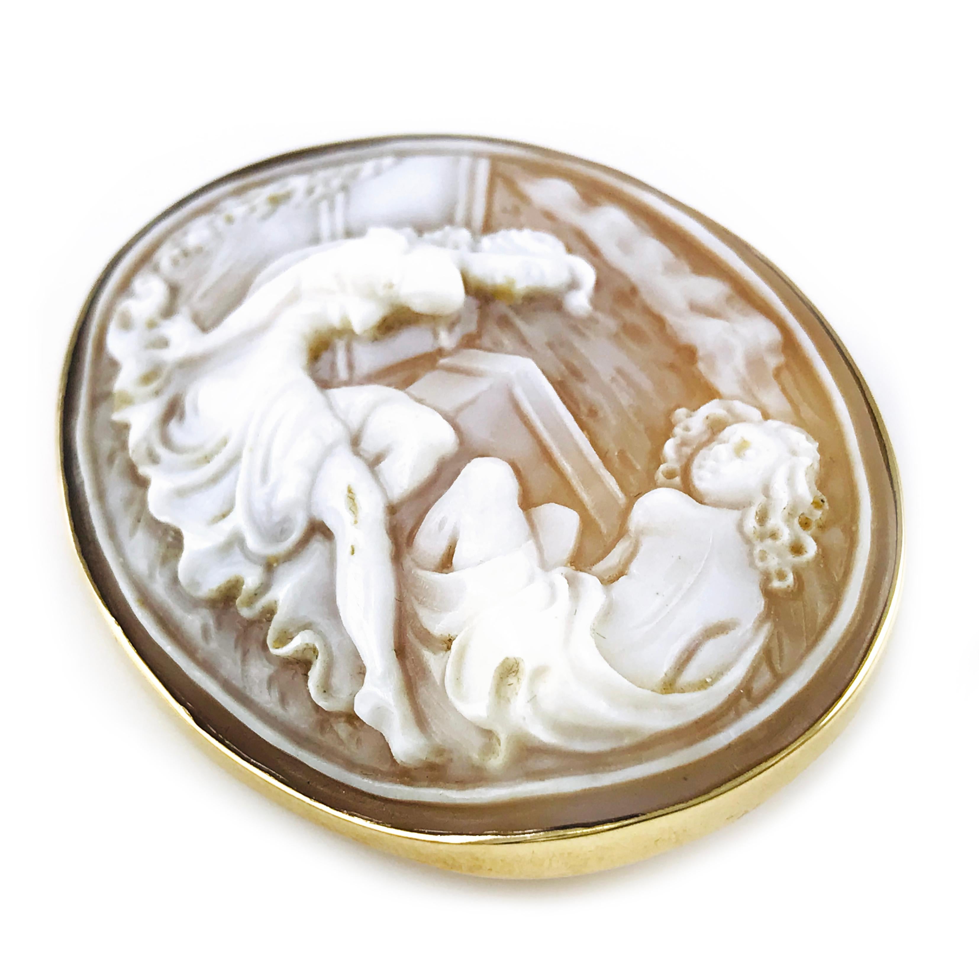 14k Yellow Gold Carved Shell Oval Bezel Cameo Brooch Pendant. Portrait of two ladies meticulously carved by an artisan in Italy. The gold bezel follows the shape and depth of the piece, a 14mm hinged enhancer and a 40mm pin on the back offer a