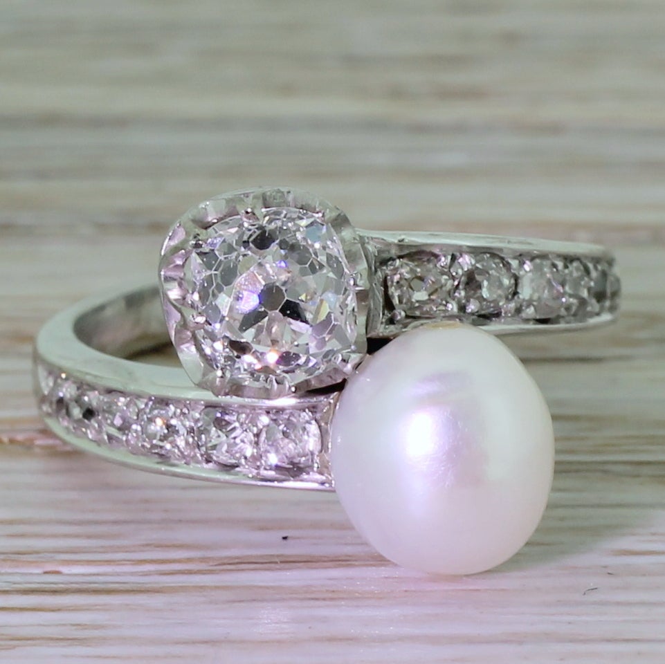 Two beautiful gems, one from the earth, one from the sea. The diamond is exceptional; extremely white and clean, and just a breath under the carat. This is paired with glorious natural pearl which displays a high luster. Set entirely in platinum,