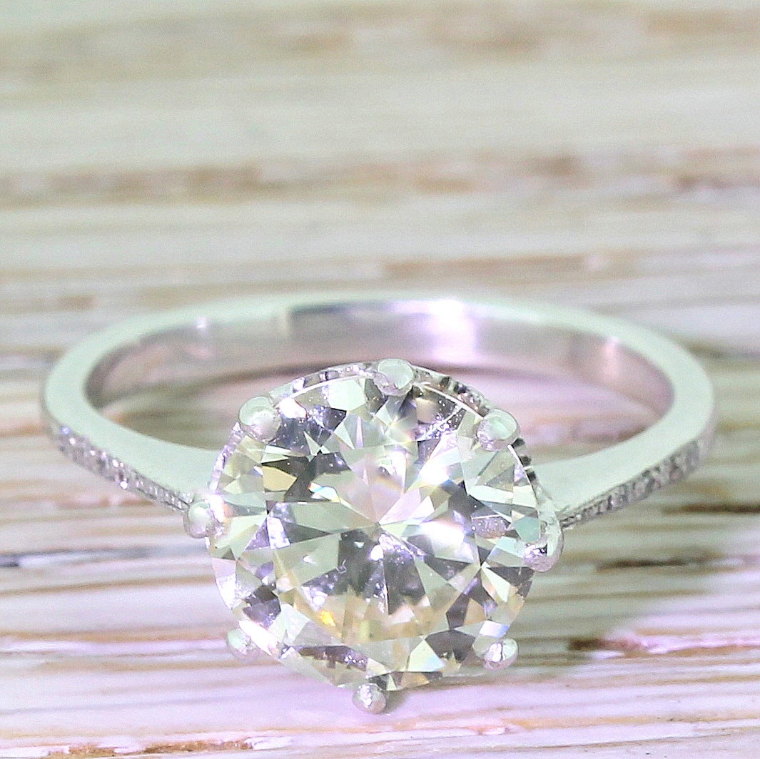 A fantastic, statement solitaire diamond engagement ring. The grand old European cut in the centre tops up much whiter than its K colour, and is set in a fine eight claw setting. A neat heart motif gallery leads to a fine, tapering white gold band