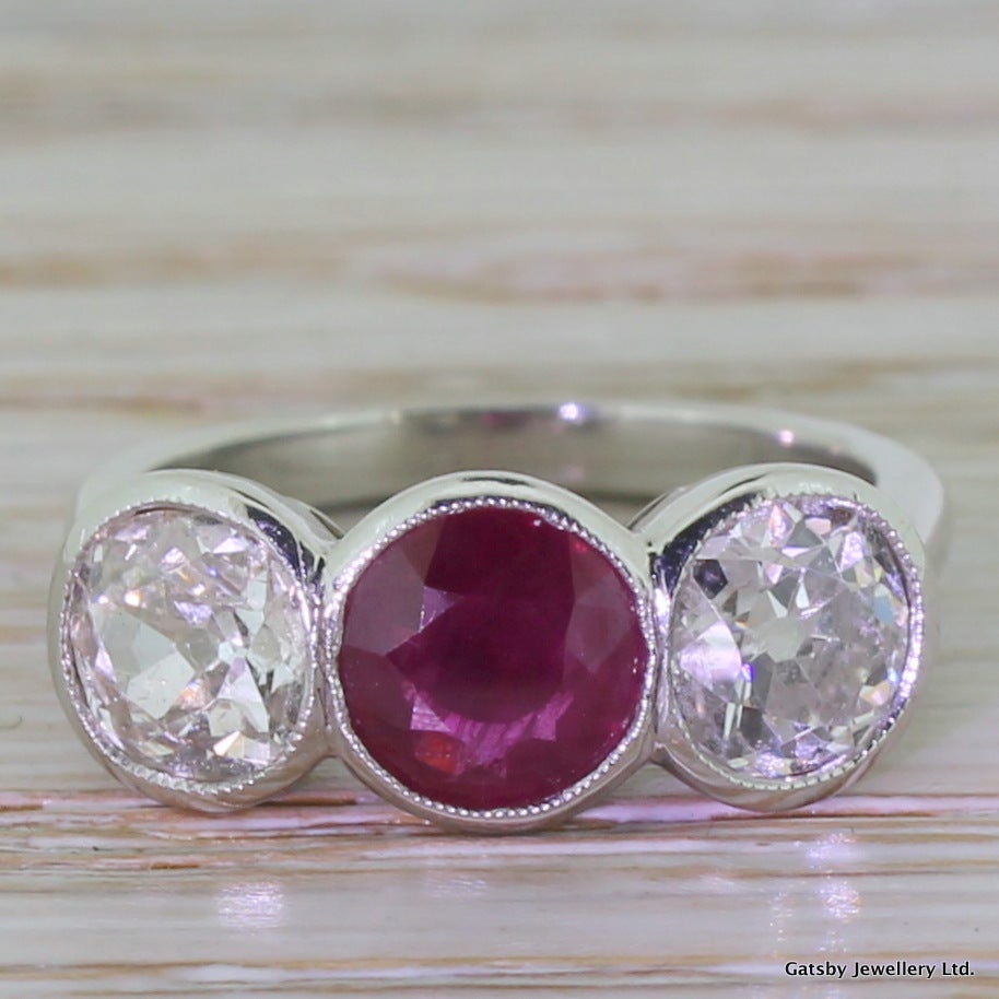 0.85 Carat Ruby & 1.70 Carat Old Cut Diamond Trilogy Ring

An impressive trio of gems in this fine  trilogy engagement ring. Three stones are of matching dimensions and are rubover and milgrain set. The ruby is a deep pigeon blood red, shot