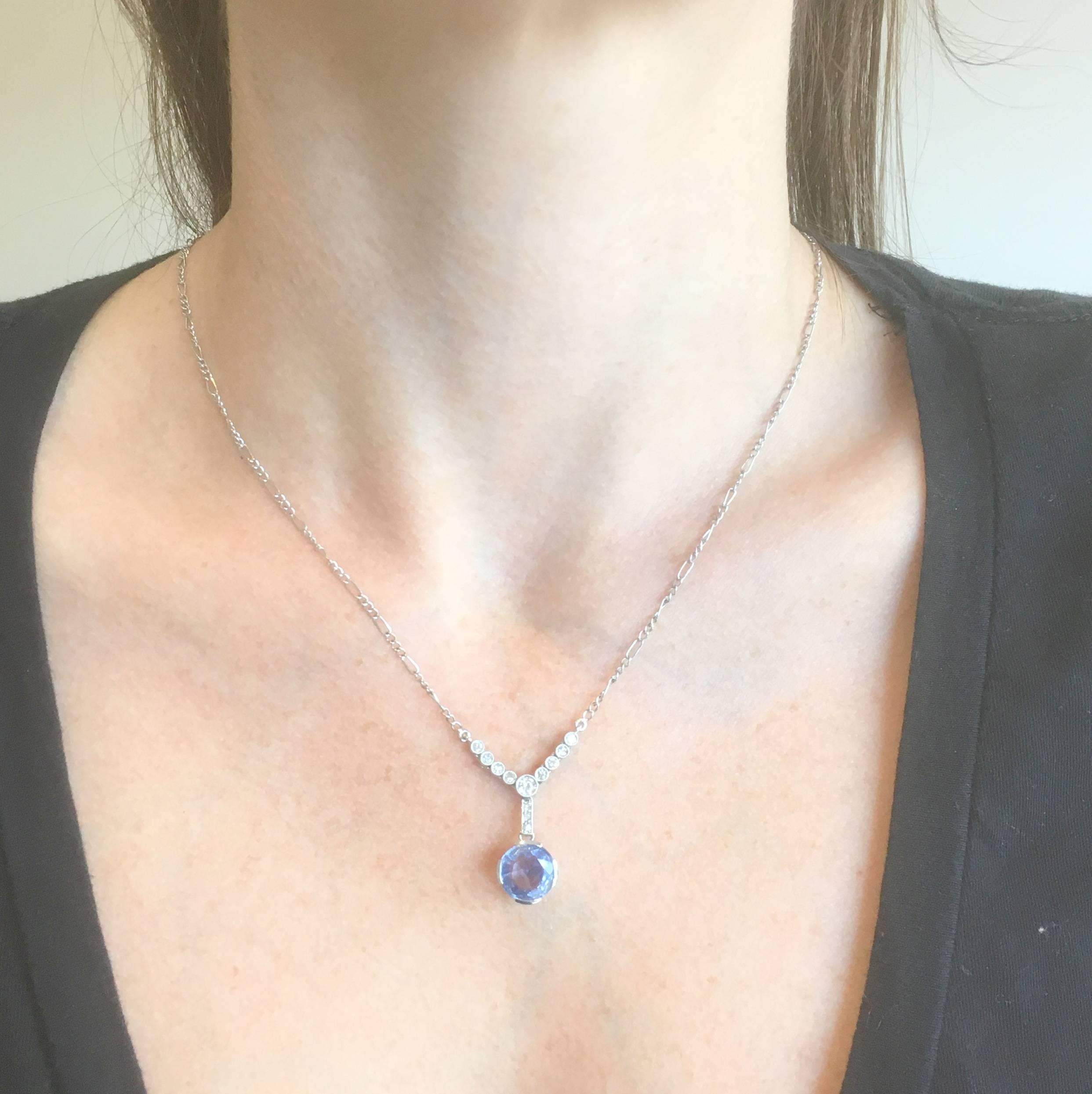 This is so pretty it almost hurts! The bright violet-ish blue sapphire is secured in the most gorgeous handmade collet with four wide claws and a highly detailed gallery. The sapphire is connected, via a diamond set linking bar, to nine articulated