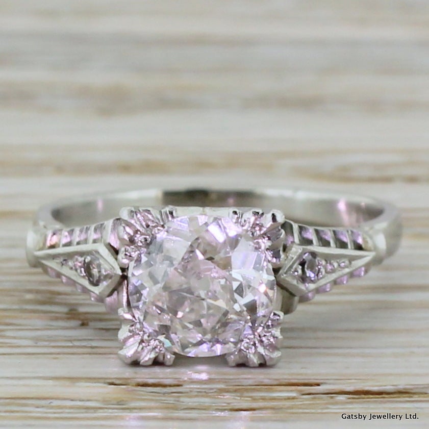 Pure Art Deco. Entirely in platinum and with strong geometric detailing and sharp lines, this is a fabulous example of Jazz Age bling. Set with a glowing and substantial old European cut of a high colour and clarity. This stunning ring is both very