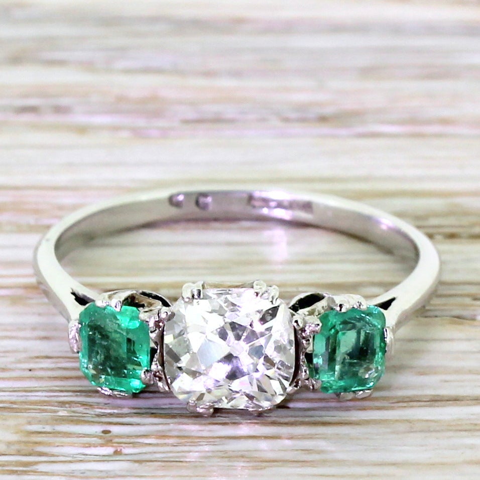 It’s the contrasts that make this Art Deco trilogy ring work: the fresh green emeralds against the high white old cut diamond; the marvellously wonky cushion shaped central stone nestled between the geometric step cut side stones. All in platinum,