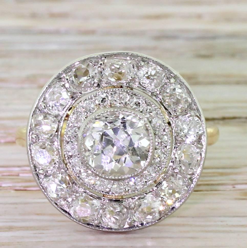 A very, very special ring indeed. The central diamond – weighing a known 1.02 carat – is rubover and milgrain set, and surrounded by 17 small old cut diamonds. This central cluster “floats” within a halo of 14 larger old cut diamonds. All the stone