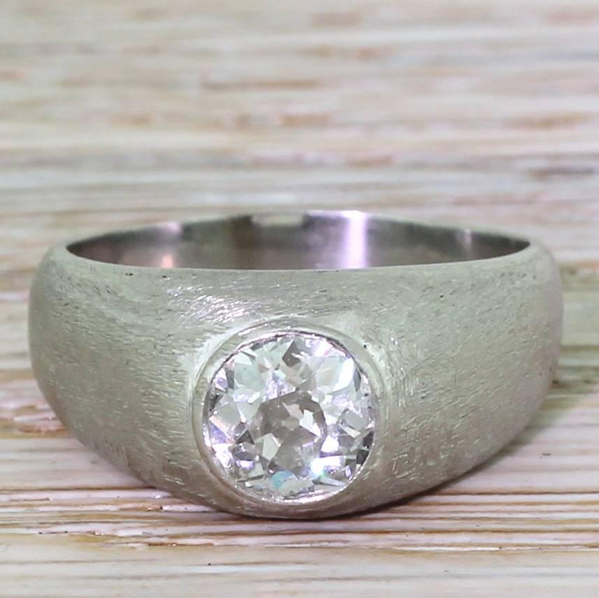 A timeless classic of a ring, suitable for either a lady or a gentleman, rendered in platinum. Centred by a high white old cut diamond bezel set within a “gypsy” mount. The brushed platinum gives this vintage ring a sleek, almost modern