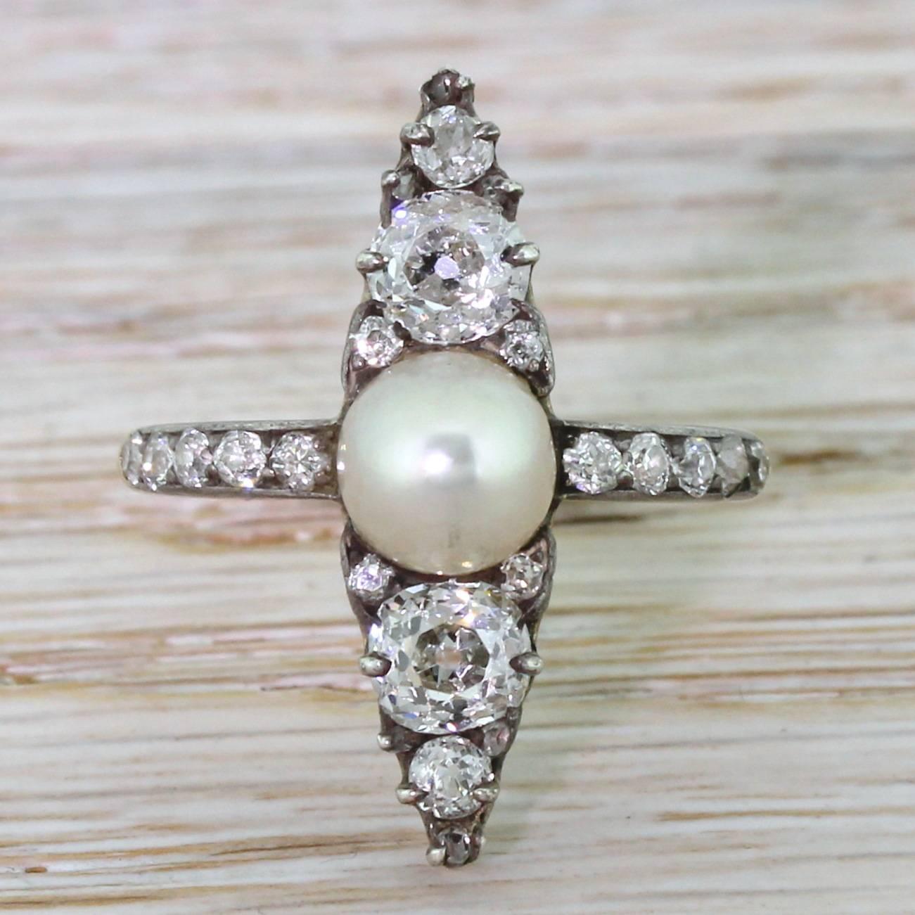 A sublime and elegant Victorian navette cluster. Centred with a natural (not cultured) pearl of a high lustre with two approximate 0.40 carat old cut diamonds either side. An overall total of twenty-four diamonds are set in silver, leading to a neat