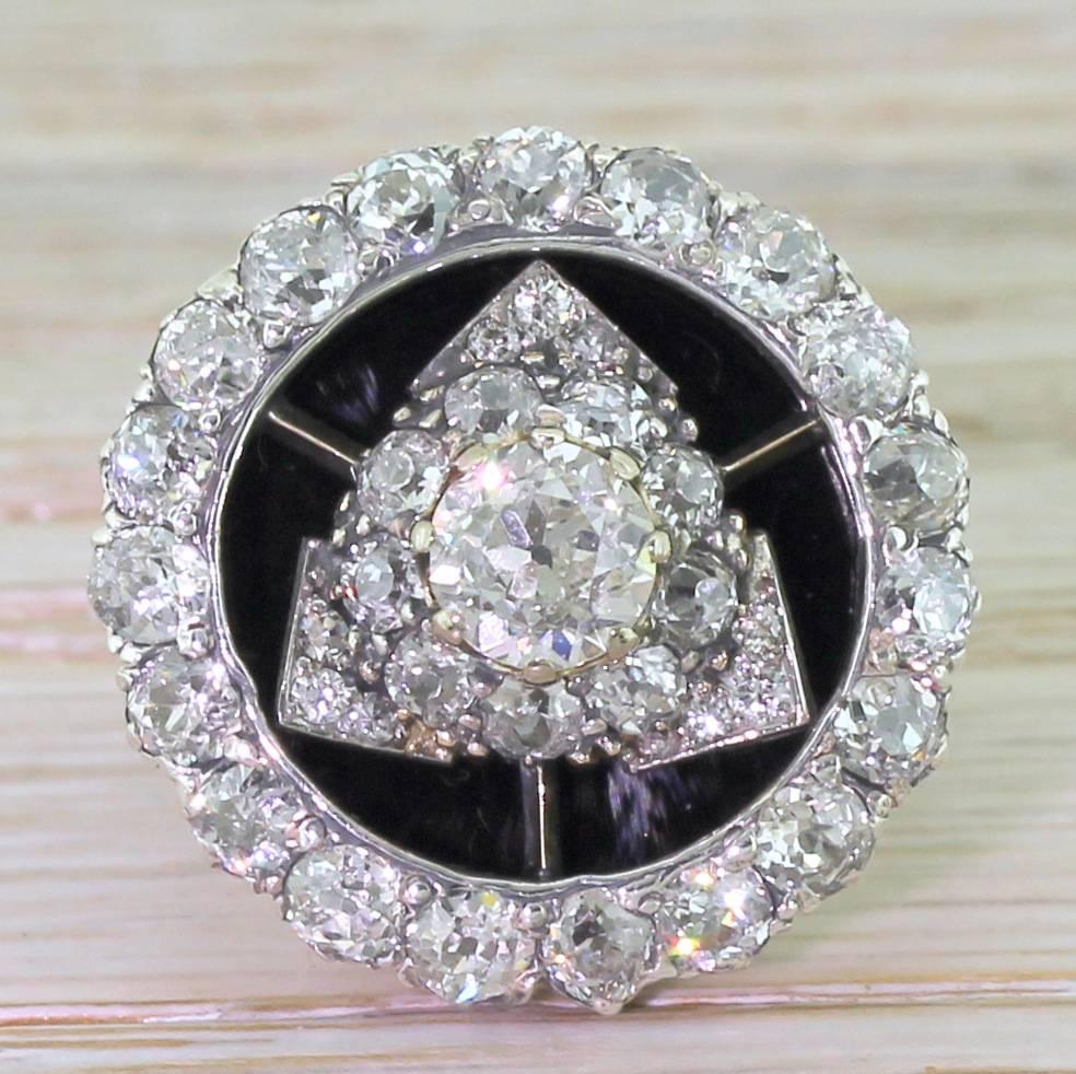 A bold and dynamic ring with a forty-four high white old cut diamonds contrasted against a black bed of onyx. The large centre stone (of approximately 0.80 carat) is set within a triangular cluster which itself surrounded by a halo cluster of