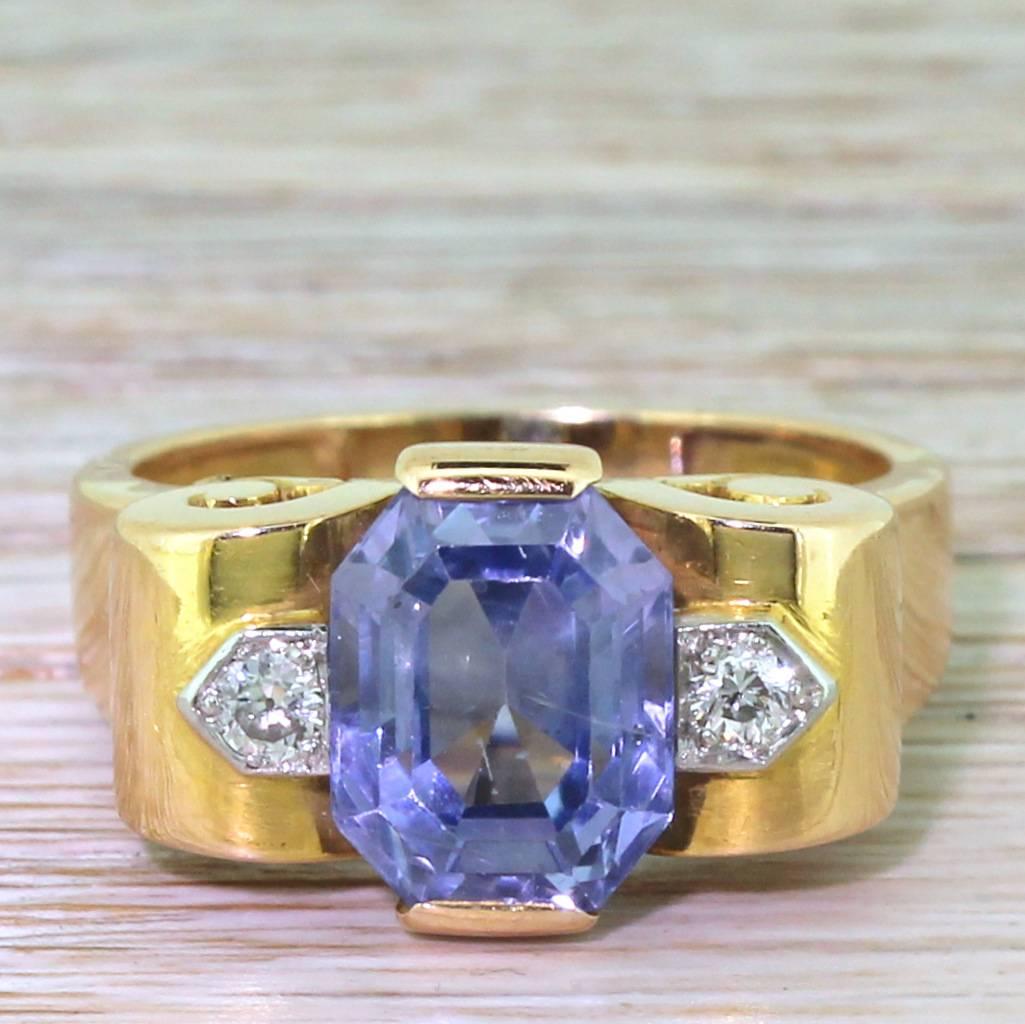 A wonderful light blue sapphire, showcased in a fine rose gold setting. The natural, unheated sapphire is safely secured by two wide claws at the north and south of the stone, with transitional cut diamonds set either side. The bold mount feature