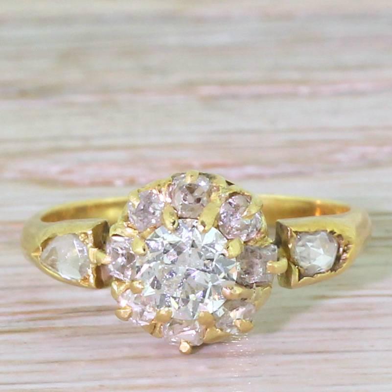 A fabulous pretty and characterful ring. The centre stone – and Old European cut – is a known 0.55 carat and displays a very high white colour. Eight surrounding stones – cushion shaped old mine cuts – are an ever so slightly lower colour,