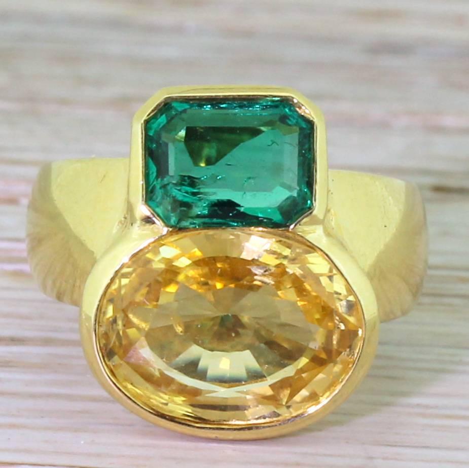 This is superbly crazy! The natural and unheated yellow sapphire sits besides an emerald cut emerald of the ideal blue-green. This wonderfully risky ring features two high quality gems of different cuts, different colours, different sizes – and yet,