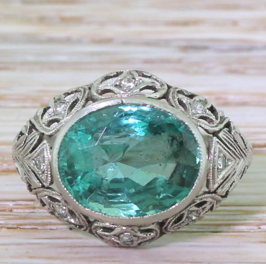 An incredibly beautiful stone in an incredibly beautiful setting. The Zambian emerald is a bright and glowing electric green with blue-ish undertones. The stone is set laterally in a rubover setting with the most intricate detailing in the gallery;