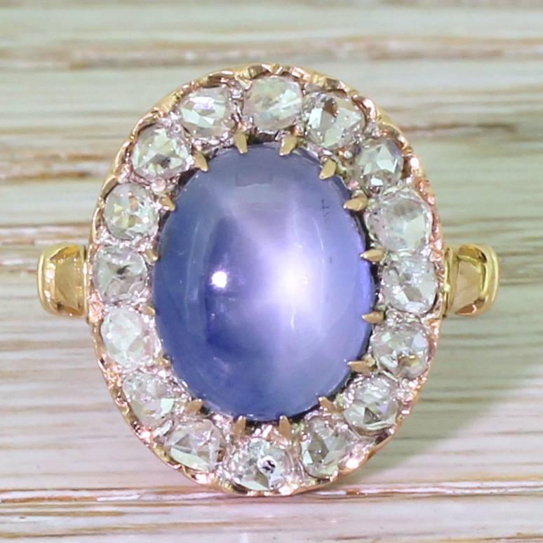 Hypnotically lovely. The large blue sapphire almost glows from within, and displays a good asterism. Sixteen high white rose cut diamonds surround the centre stone, set in a beautifully refined pierced gallery. The tri-split shoulders lead to a