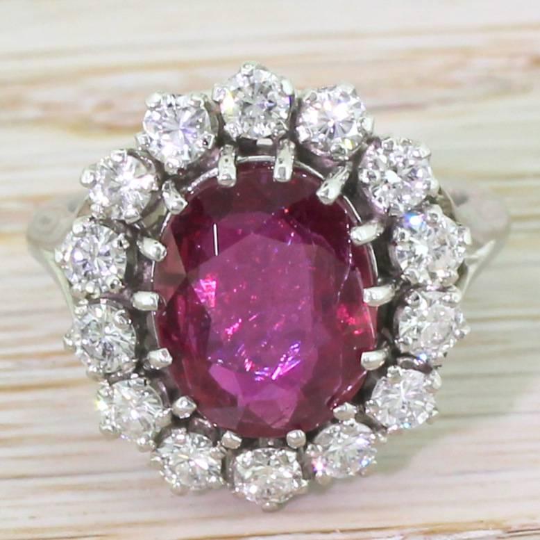 Sophisticated and elegant. The high quality Thai ruby displays a deep red with clear flashes of crimson, and is surrounded by fourteen brilliant cut diamonds of the highest quality. The round cheniers in the gallery are interspersed with triangle