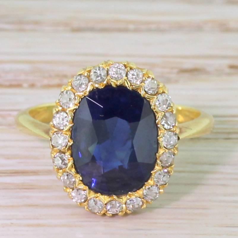 Utterly arresting. The natural and unheated sapphire of a deep, royal blue displays a quite mesmerising lustre. A total of twenty old cut diamonds surround the centre stone in a incredibly precise “U” gallery with double claws, leading a slim and