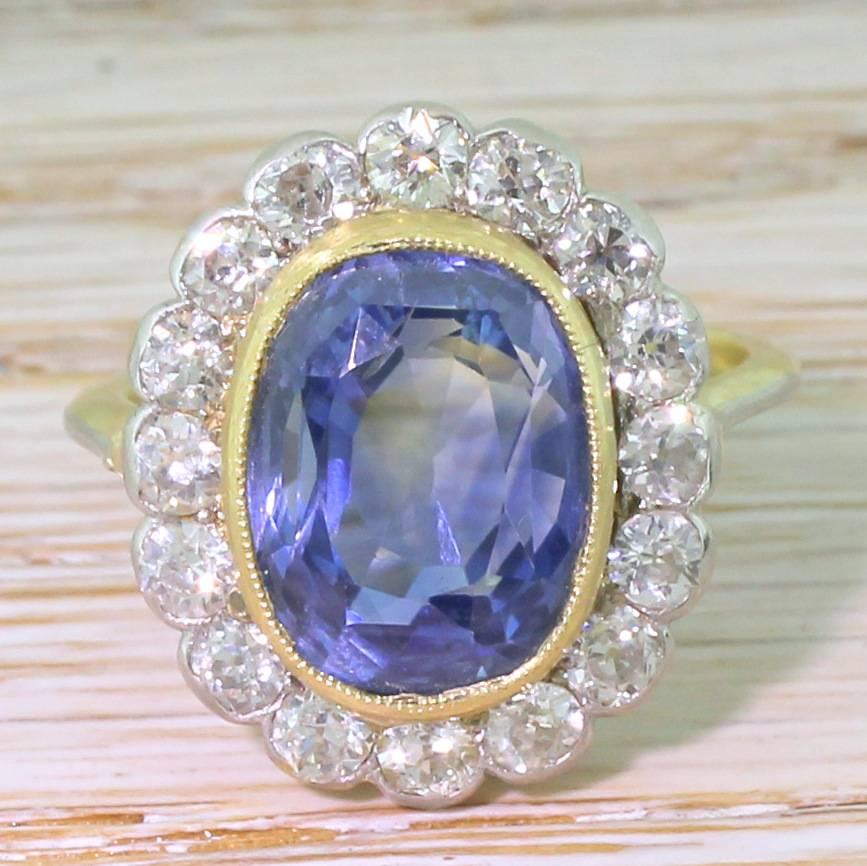 Sublime. The natural, unheated Ceylon sapphire is a mesmeric cornflower blue. The stone is rubover and milgrain set in yellow gold, with sixteen high white old cut diamond set in platinum in the surround. The slim, tapering shank is topped with