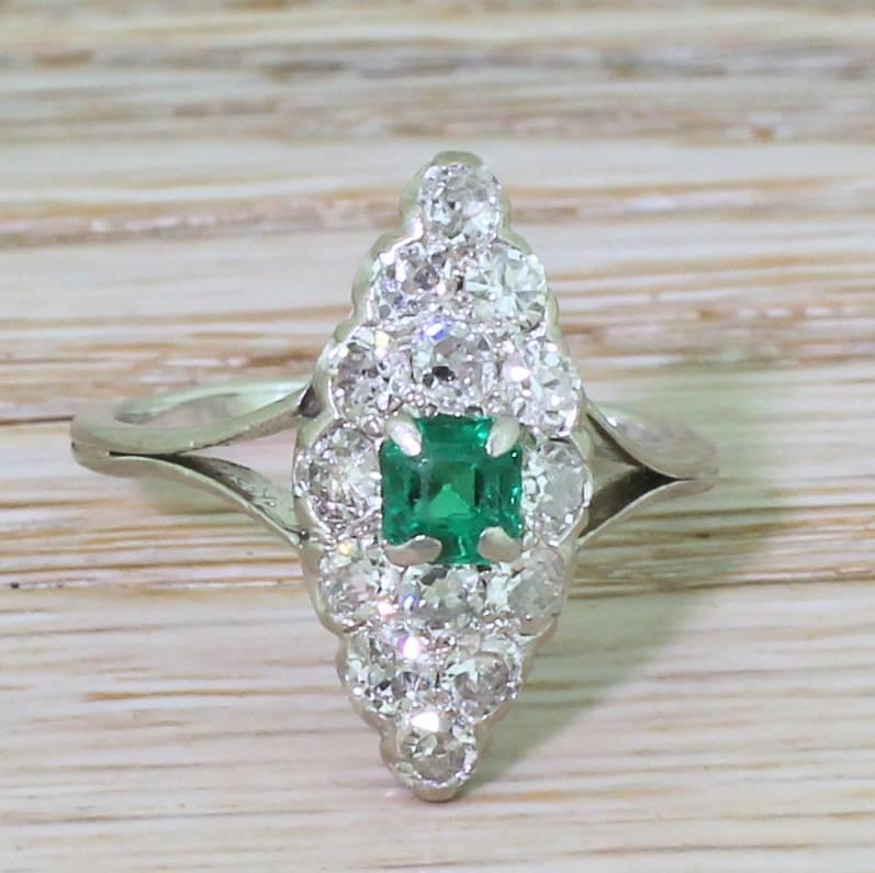 A French navette beauty. The square step cut Colombian emerald in the centre is a perfect glowing green with heaps of life and lustre. Fourteen white and clean old cut and eight-cut diamonds form the rest of the navette with fine “U” detailing in