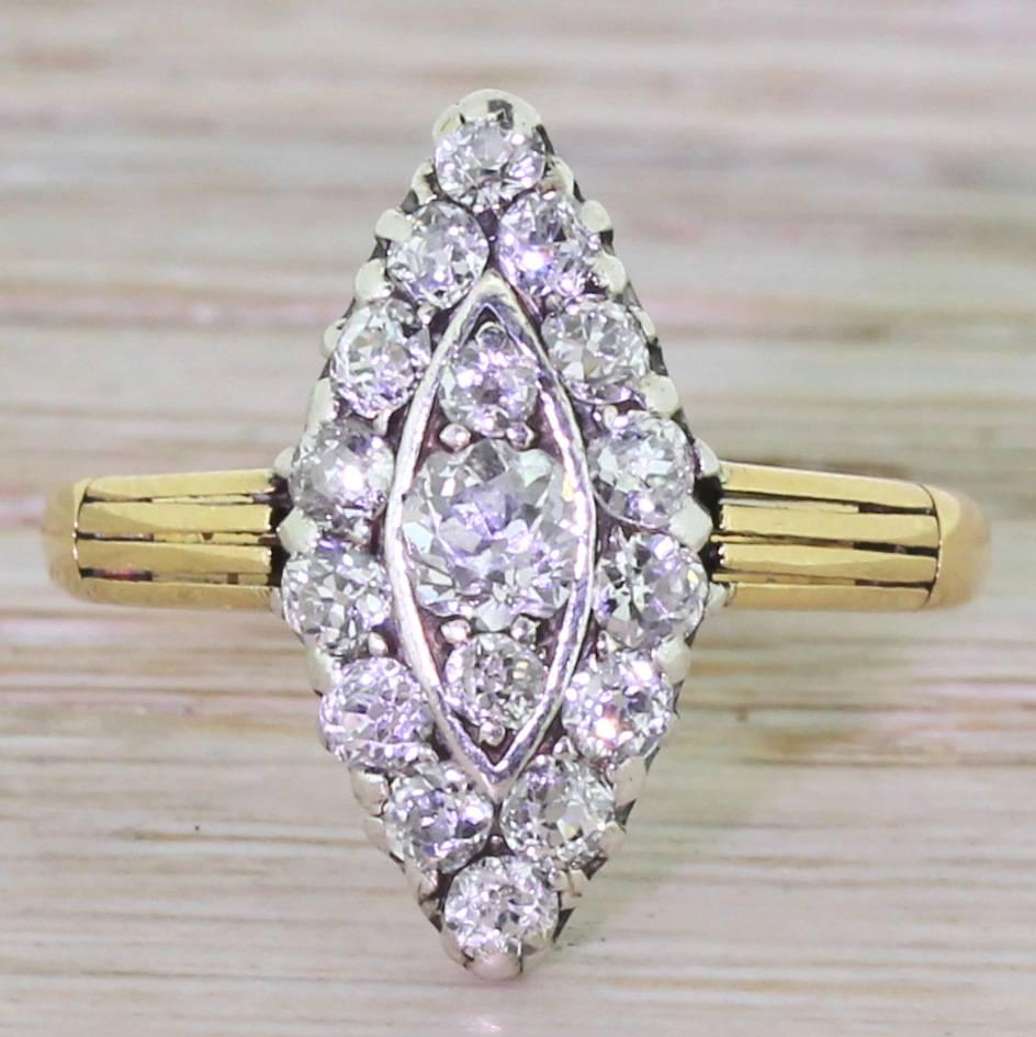 An extremely impressive old mine cut diamond navette cluster ring. Set with seventeen bright white and clear diamonds on pierced gallery. The cluster sits nice and snug to the finger, and leads to a solid D-shaped yellow gold band featuring vented