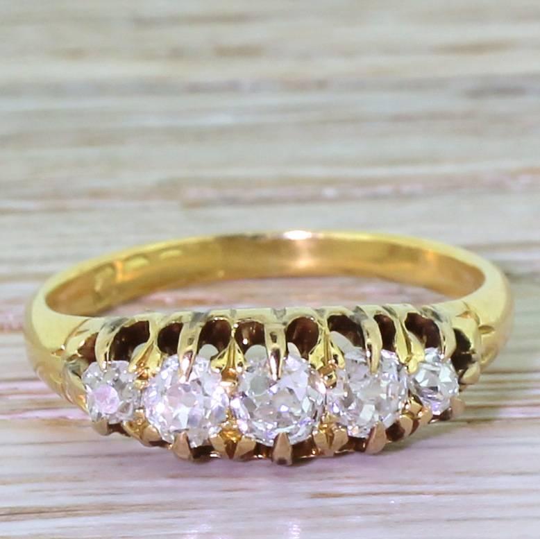 A classic English five stone with a dazzling quintet of old cut diamonds. The graduating line of stones are high white with excellent clarity. Claw set in a pierced open gallery, leading to D-shaped yellow gold band.  Would work equally well on it’s