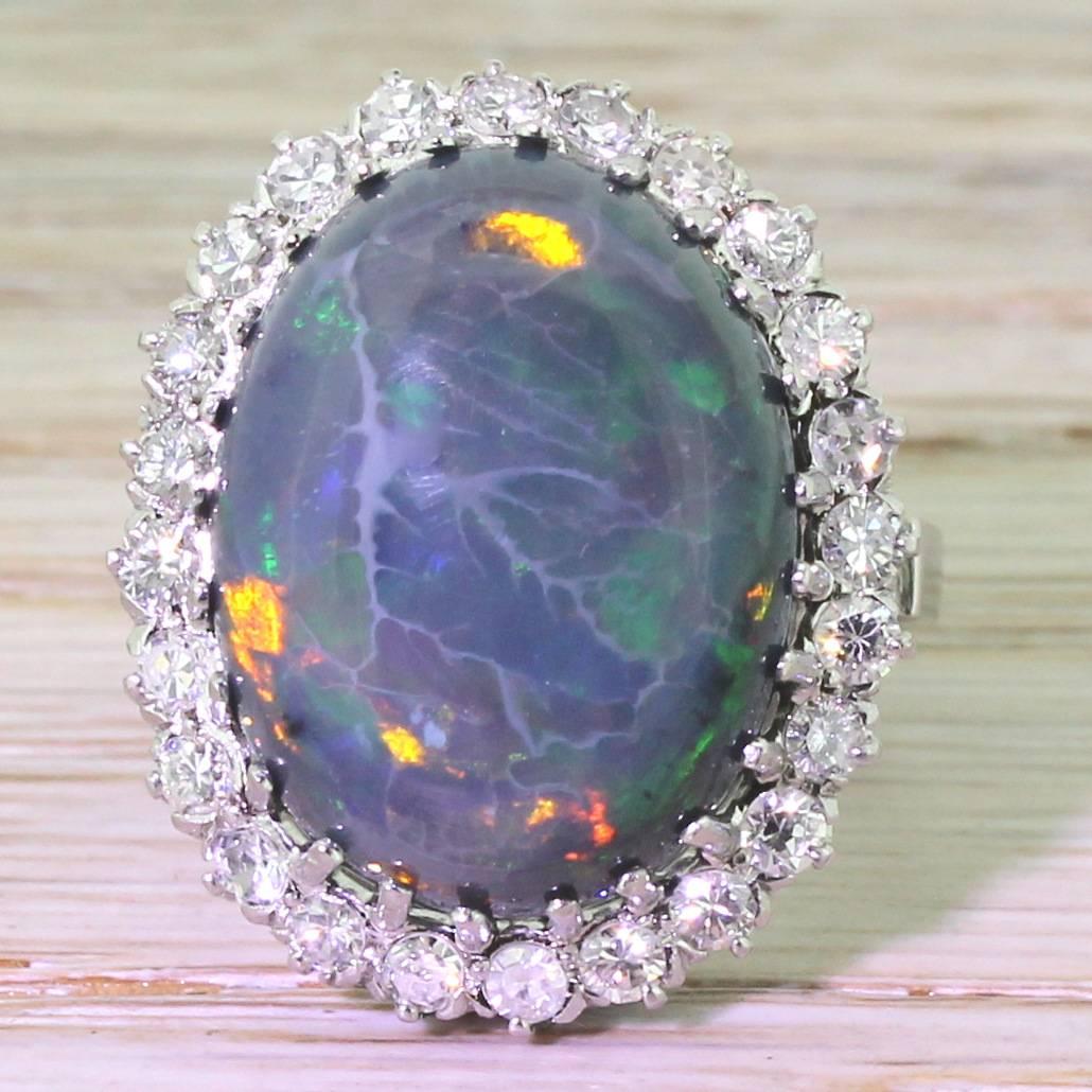 There are statement rings, and then there is this. An entirely natural black opal with an impressive play of colour; green, orange, red and blue. The stone is claw set in a mount set with 24 high white eight-cut diamonds in an intricately pierced