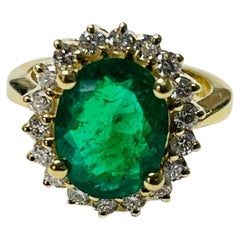 Anello di fidanzamento con smeraldo ovale e diamante in oro giallo 18 carati.