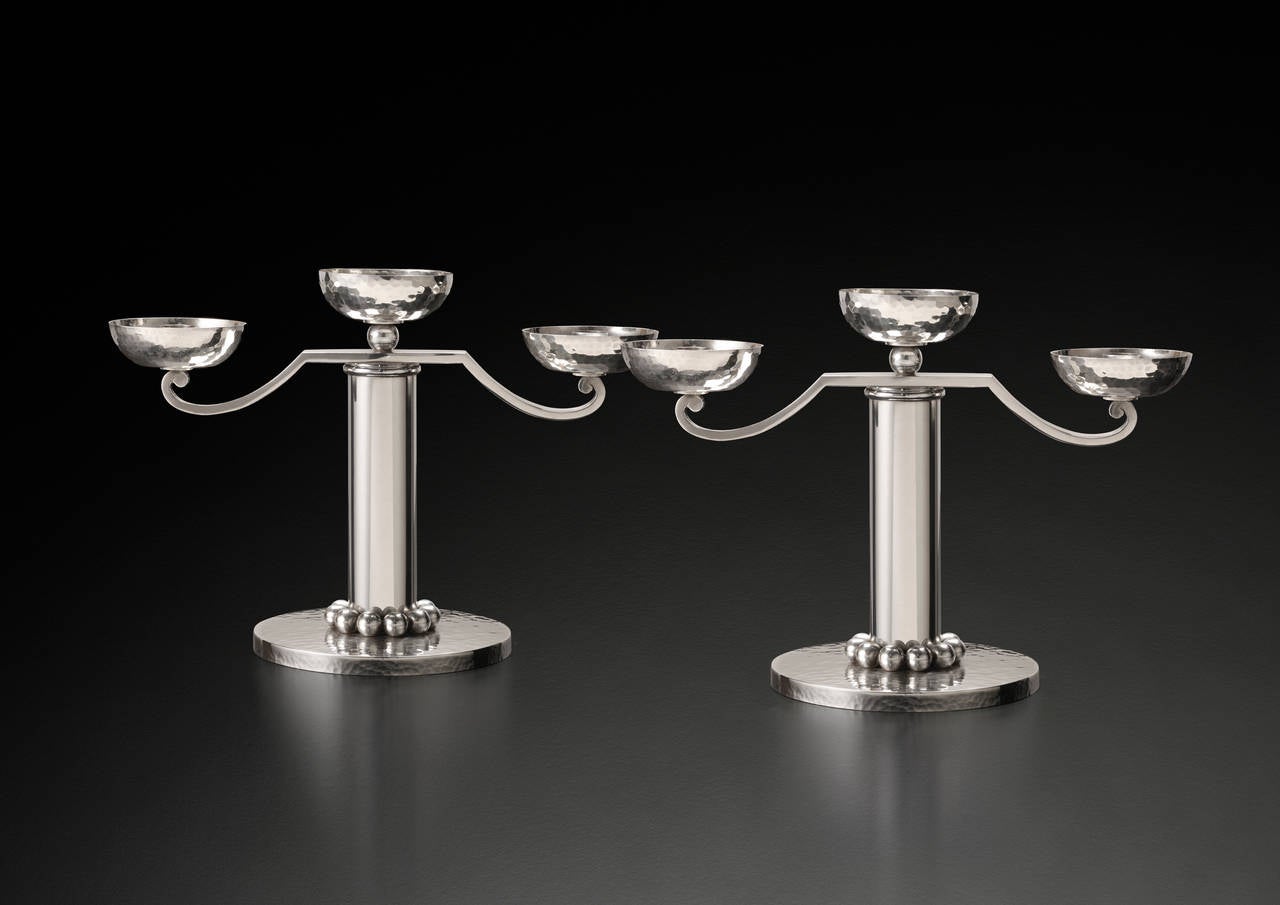 Jean DESPRES

Pair of 3-lights hammered candelabra

Paris Ca. 1940

Signed: Jean Despres

Pair of Jean Desprès 3-lights candelabra, cylindrical drums with a frieze of small spheres and a snap ring on the upper part. Arms ending in volutes on