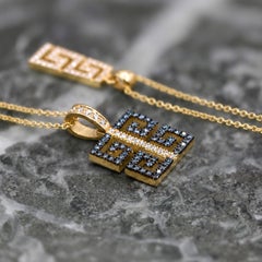 Georgios Collections: ciondolo in oro giallo 18 carati con motivo a greca, diamanti blu e bianchi