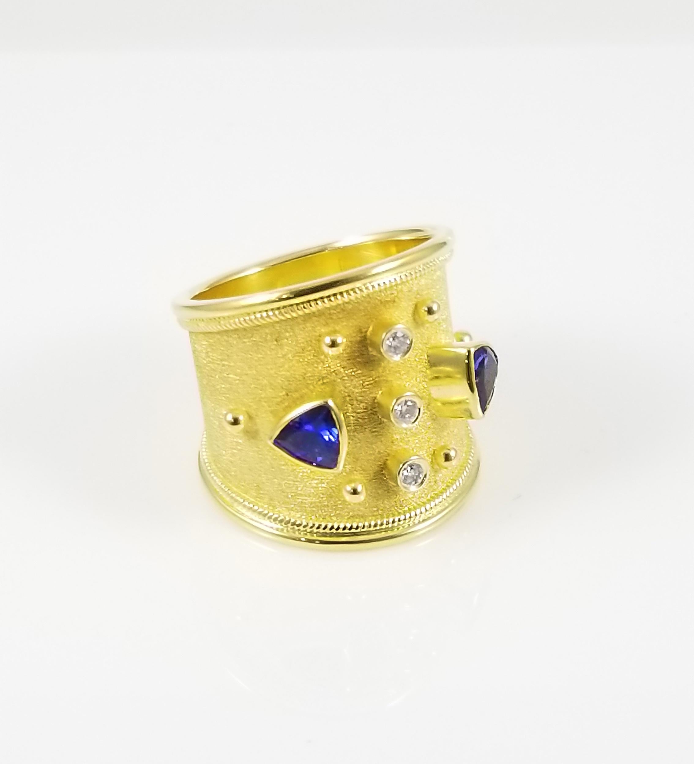 S.Georgios designer 18 Karat Solid Yellow Gold Ring all handmade with Byzantine workmanship and unique velvet look in the background. The stunning ring has Granulation work and is decorated microscopically and features two natural trillions cut