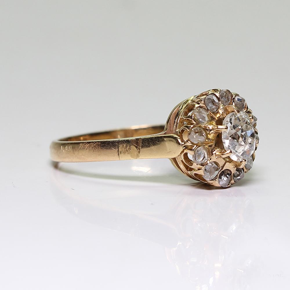 Period: Victorian (1836-1901)
Composition: 18K Gold.
Stones:
•	1 Old mine cut diamond of H-VS2 quality that weighs 0.70ctw.
•	12 Rose cut diamonds of J-SI1 quality that weigh 0.15ctw.
Ring size: 8 ¼   
Ring face:  10mm in diameter.
Rise above