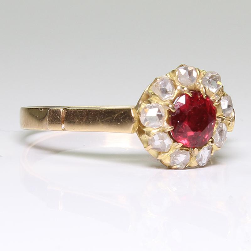 Period: Victorian (1836-1901)
Composition: 18K gold.
Stones:
•	1 synthetic round cut ruby that weigh 1ctw.
•	10 Rose cut diamonds of H-SI1 quality that weigh 0.40ctw.
Ring size: 6 ¾     
Ring Face:  9mm in diameter.
Rise above finger: 6
Total