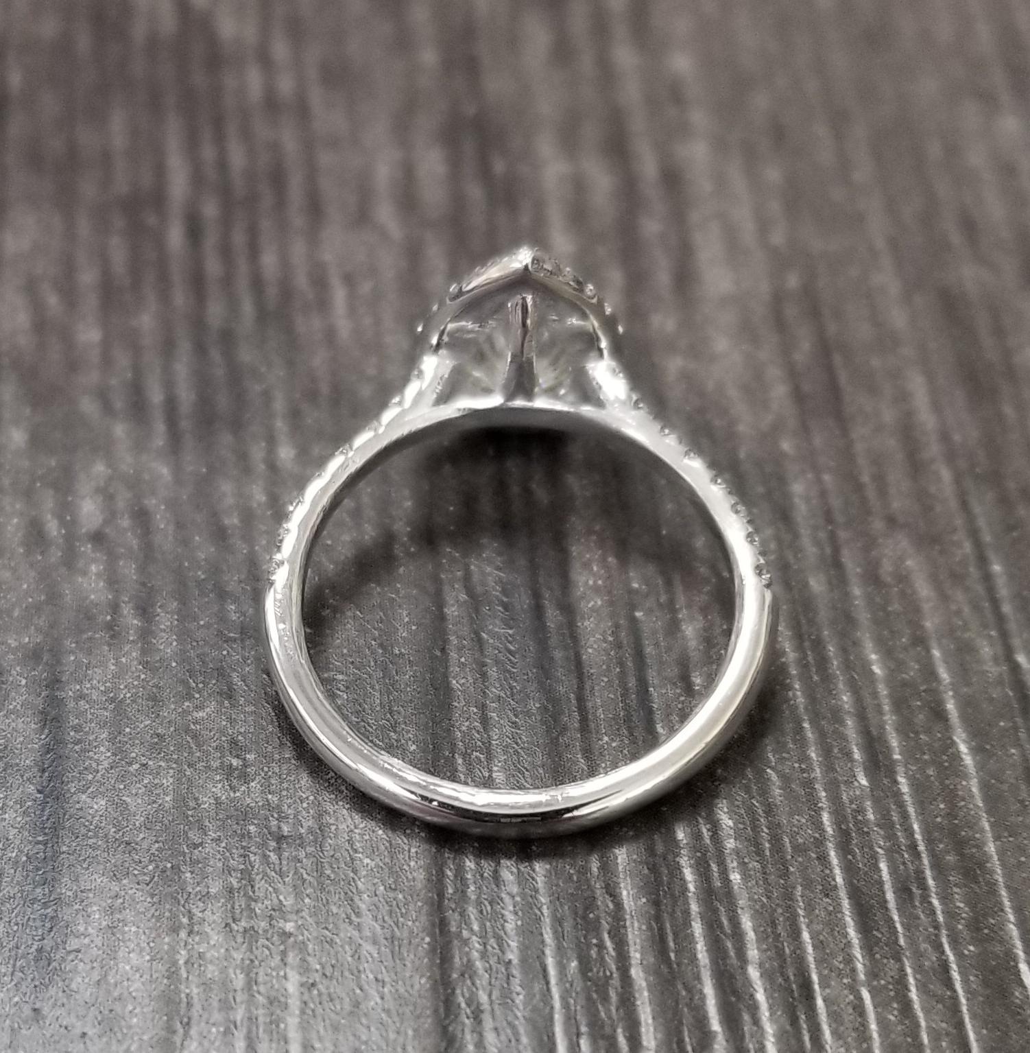 14k white gold ladies diamond ring, containing 1 pear shape diamond weighing 1.00cts. and 36 round full cut diamonds of very fine quality weighing .27pts.