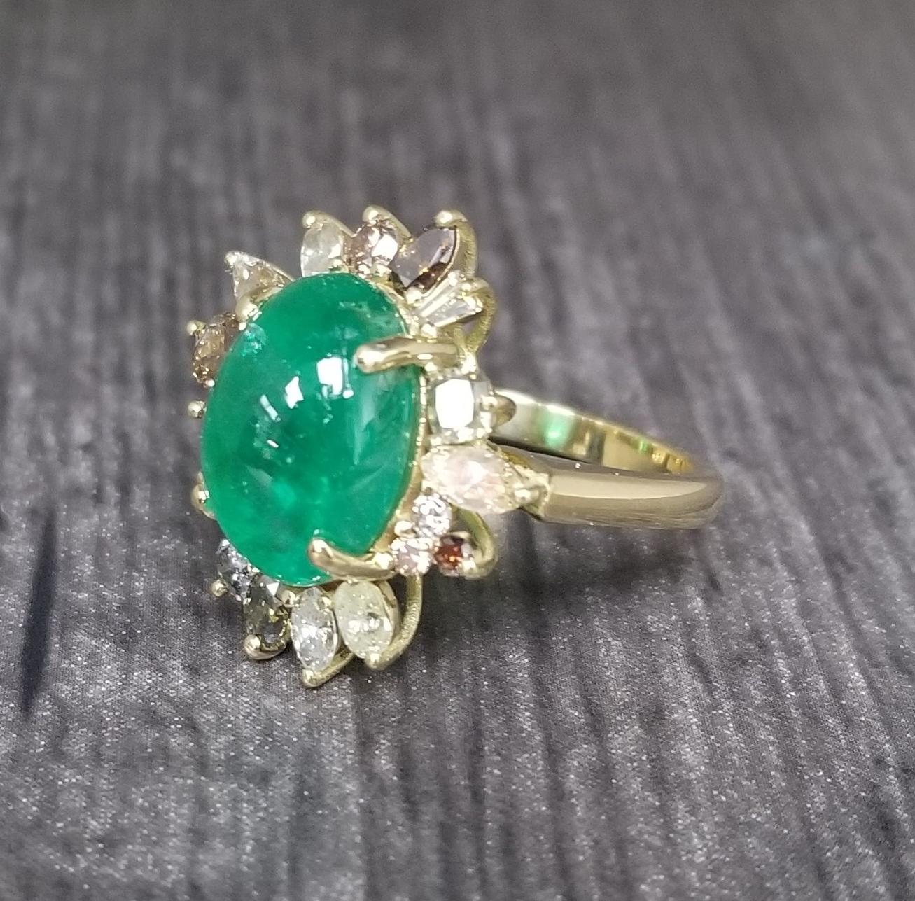 18k yellow gold ladies emerald and diamond ring containing, 1 cabochon cut emerald weighing 6.18cts. and 17 natural diamonds; color white, yellow, and brown, weighing 1.68cts.  This ring is a size 6.5 but we will size to fit for free.