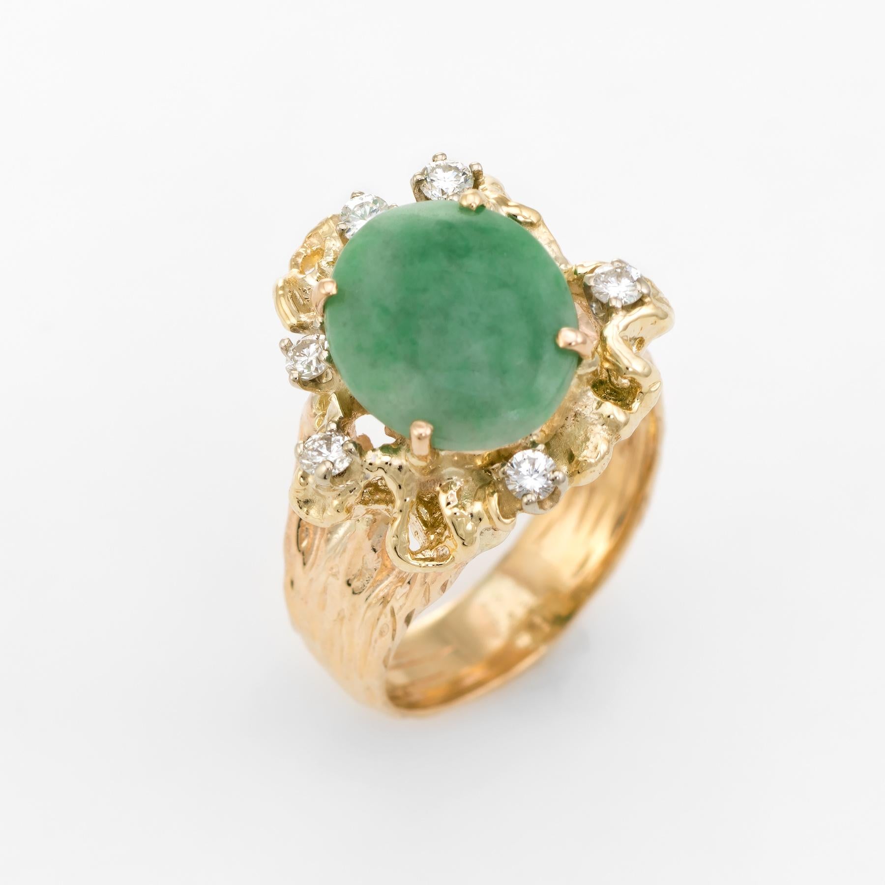Distinct and unusual vintage nugget cocktail ring (circa 1960s to 1970s), crafted in 14 karat yellow gold. 

Oval cabochon cut jade measures 12mm x 9.75mm (estimated at 6 carats), accented with 6 approx. 0.03 carat round brilliant cut diamonds. The