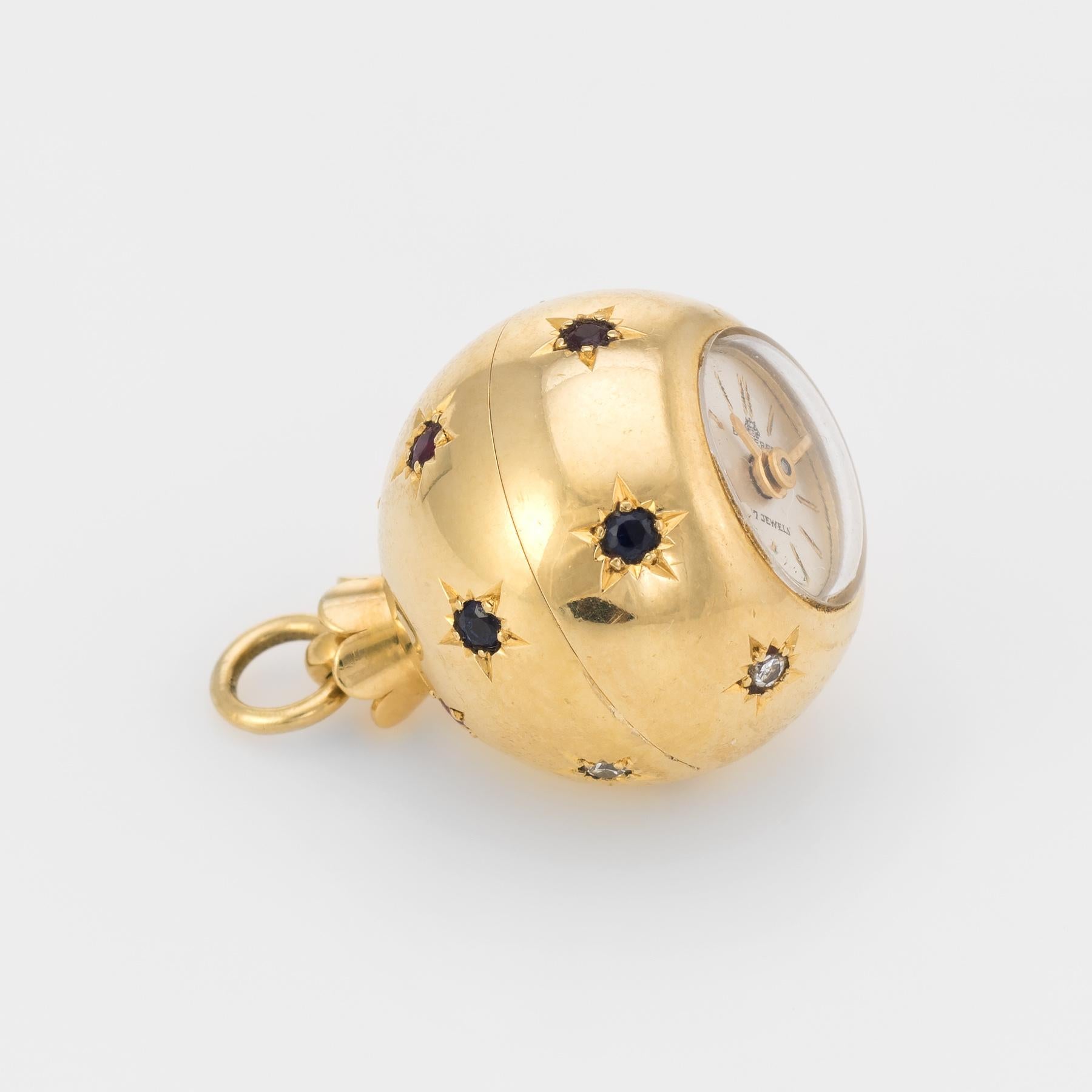 Finely detailed Bucherer pendant watch, crafted in 18 karat yellow gold.

The orb is set with diamonds that total an estimated 0.06 carats (estimated at I color and SI1 clarity), sapphires total an estimated 0.05 carats and rubies total an estimated
