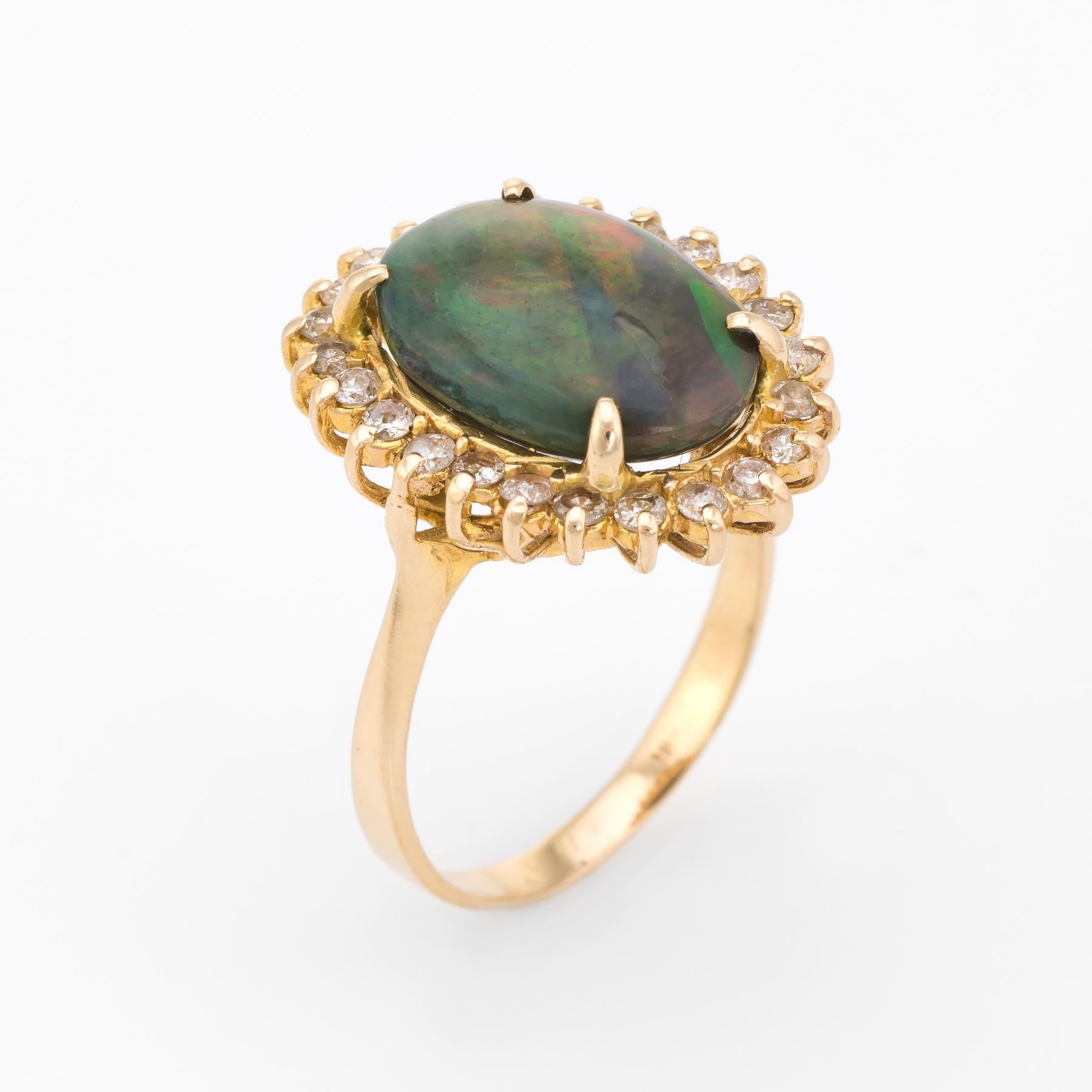 Finely detailed vintage natural black opal & diamond cocktail ring, crafted in 18 karat yellow gold. 

Centrally mounted oval cabochon cut natural black opal, approx. 4.75ct (14.75 x 10.25 x 5.40mm), with a distinct orange/yellow/green/blue