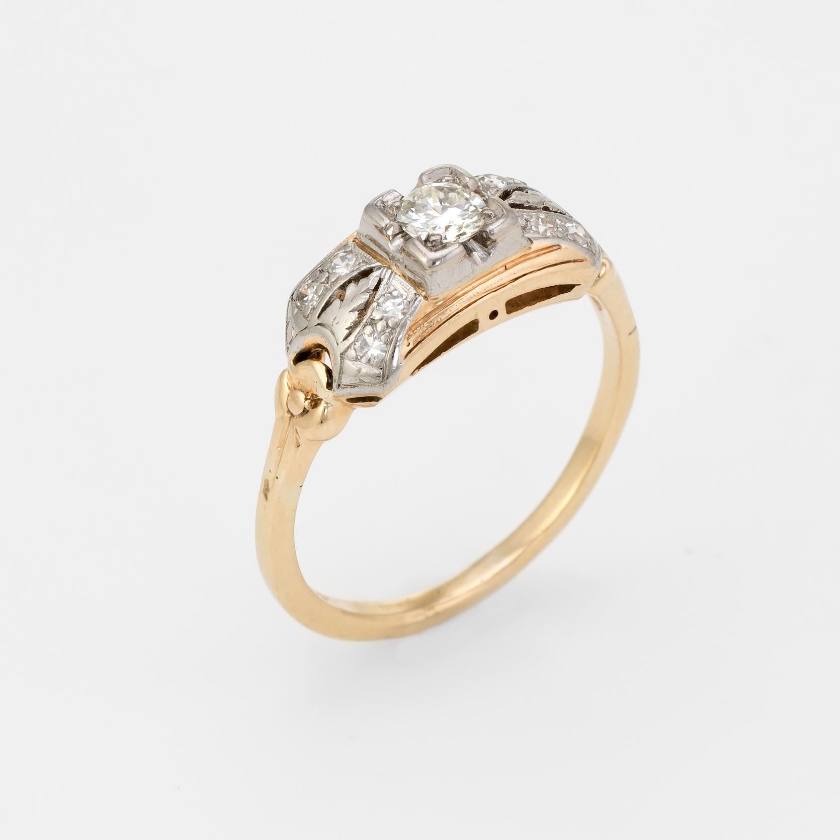 Finely detailed vintage Art Deco era engagement ring (circa 1920s to 1930s), crafted in two tone 14k yellow and white gold. 

Centrally mounted estimated 0.20 carat transitional cut diamond is accented with a further 8 estimated 0.01 carat single