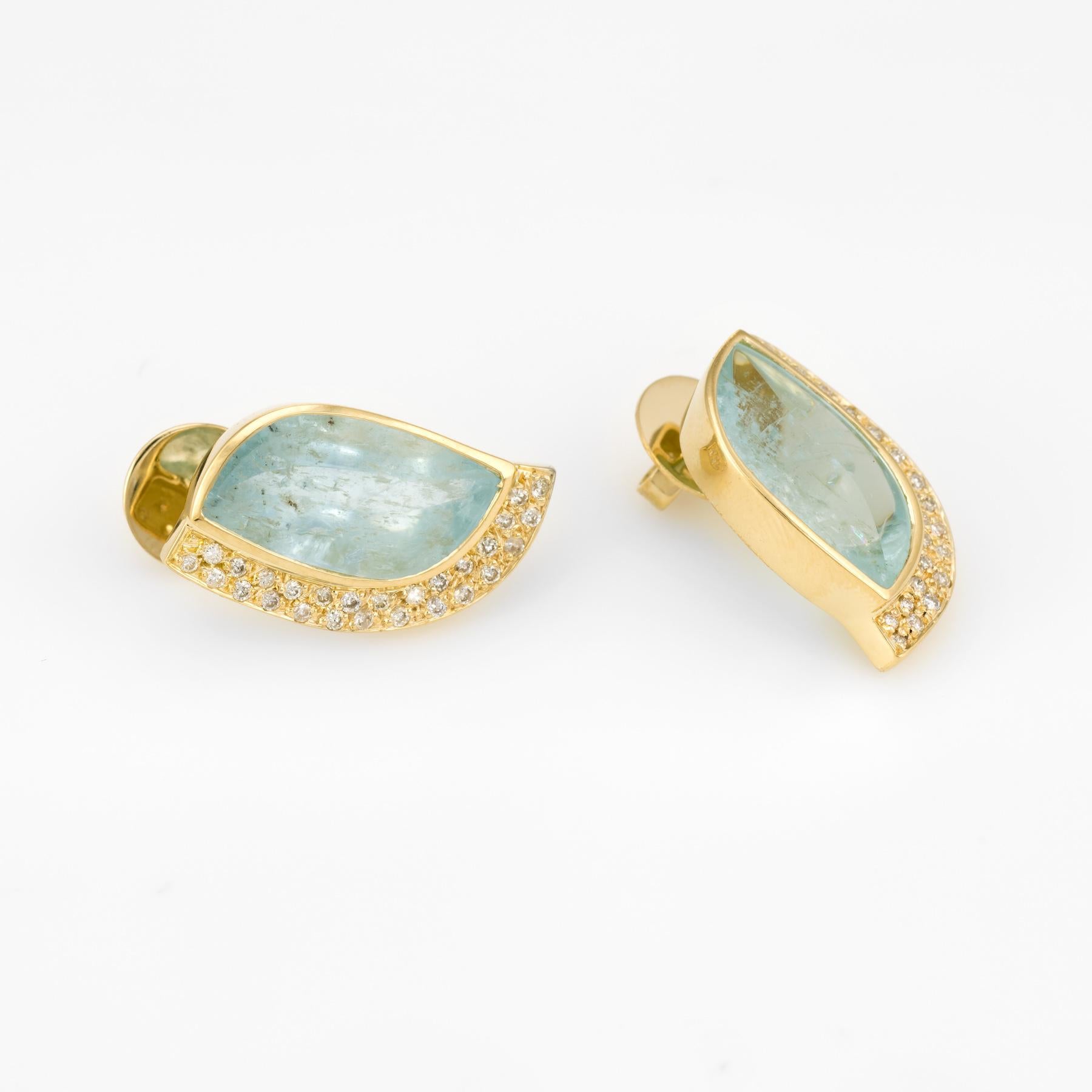 Stylish pair of vintage aquamarine & diamond earrings (circa 1980s), crafted in 18k yellow gold. 

Two pieces of aquamarine measure 18mm x 10mm. The aquamarine features a low dome smooth cabochon cut with a center pointed ridge cut curved to the