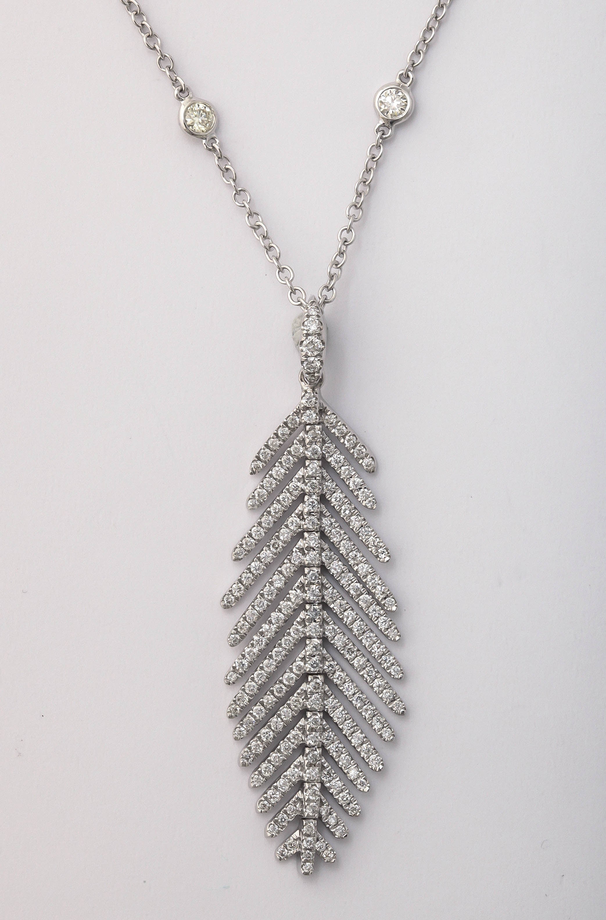 flexible feather pendant
2 inches long
1/2 inch wide
194 diamonds 1.00 carat
suspended from 18k white gold and diamond chain
16 diamonds 0.75 carats
18