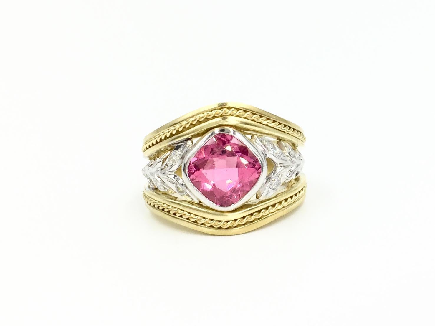 Made by SeidenGang. This unique 18 karat two tone gold ring features a bright cushion cut pink tourmaline center. A cut out leaf design has a diamond set in the center of each leaf with a total weight of .27 carats. Ring has a width of 11mm and