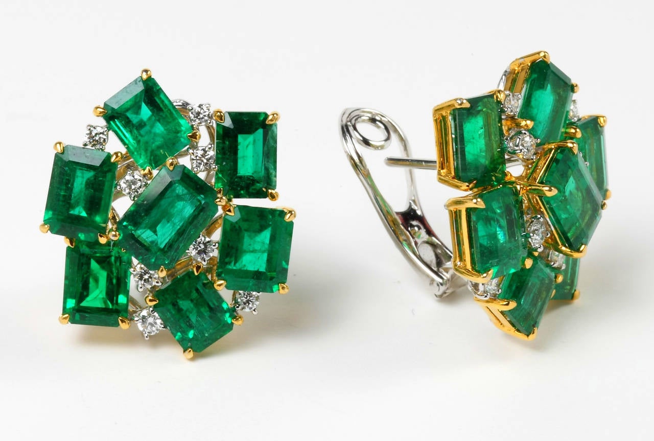 This luxurious pair of certified vivid green emerald earrings in 18K white and yellow gold is set with eye-catching emerald-cut emerald gemstones and also accentuated with diamonds for added sparkle.  Earrings are fitted with omega clip and post