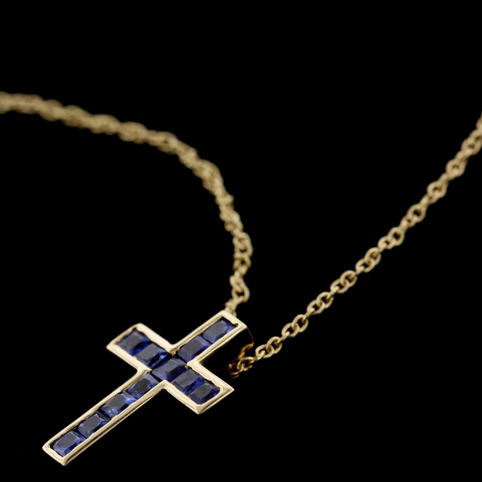 Tiffany & Co. 18K Yellow Gold Sapphire Cross. The cross is channel set with
11 square cut sapphires, approx. total wt. .65cts., length 5/8