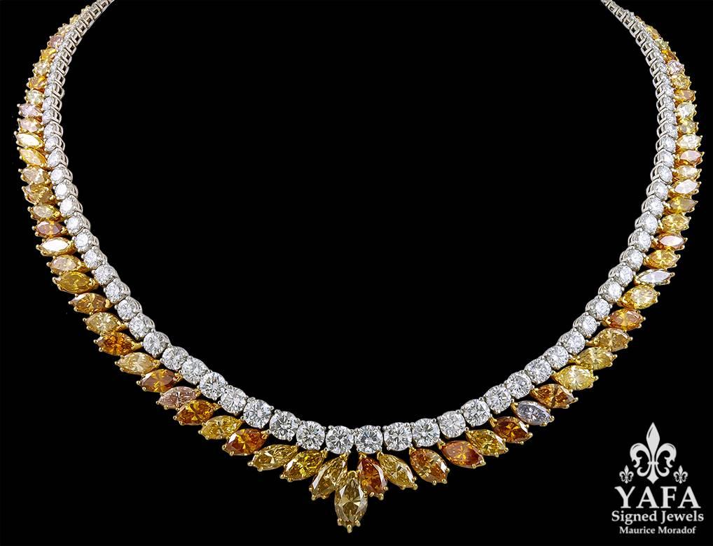 A white and fancy-colored diamond necklace mounted in platinum; designed as a fan of marquise-shaped colored diamonds in an autumnal range of colors including green, orange, yellow and brownish hues, suspended from a simple rown of brilliant-cut