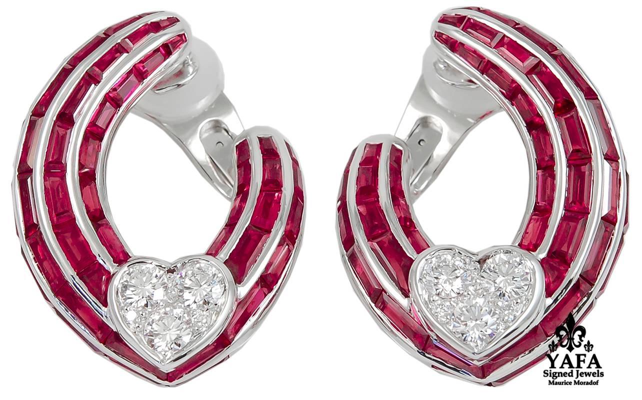 GRAFF Ruby Diamond Heart Hoop Earrings in 18k White Gold.

A contemporary pair of torqued hoop earrings by Graff intended to rest asymetrically on the ear. Ribbed channels of calibré-cut rubies cascade down the ear into charming hearts of round