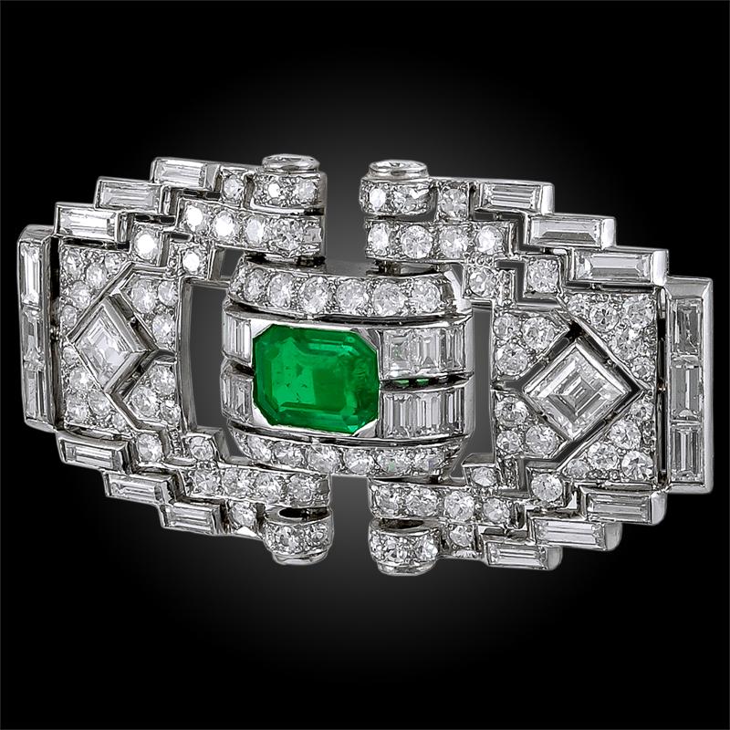 A stunning art deco diamond brooch of geometric openwork design, crafted in the 1920s, centering an outstanding emerald cut emerald of exceptional brilliance at the center of round, baguette and emerald cut diamonds.
Signed Mauboussin.
Made in France