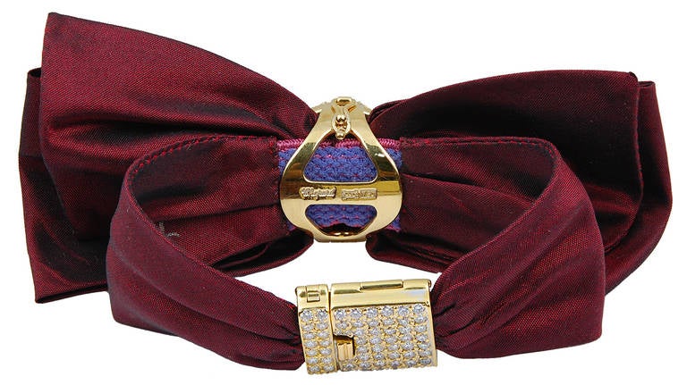  A Chopard lady's 18k yellow gold and diamond 'Alta Moda' bow bracelet watch, on a burgundy ribbon strap with diamond clasp and pave-set diamond case.

Signed Chopard.